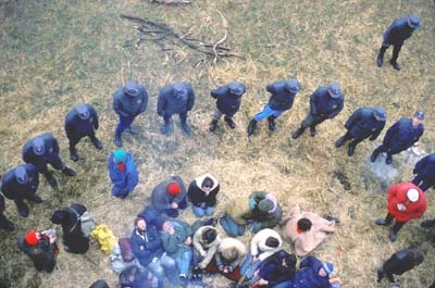 Blick von oben auf eine Gruppe Besetzer die von Uniformierten eingekreist sind.