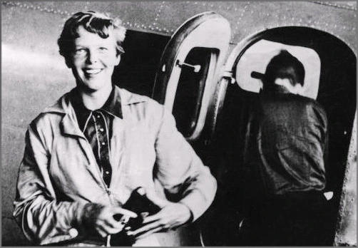 Fotografie der Fliegerin Amelia Earhart vor einem Flugzeug