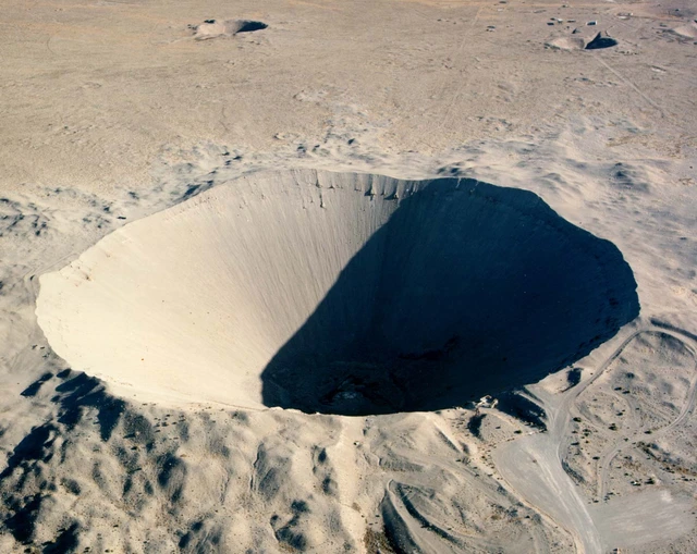 Ein großes Sandloch in einer sandigen Wüste.