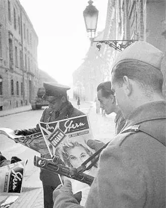 Befaffnete Soldaten mit Stern-Ausgaben in der Hand.