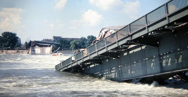 Donau mit rechts einem großen Teil der Reichsbrücke. Weiter hinten kann man das andere Ufer mit Brückenteilen und wahrscheinlich dem Linienautobus erkennen.