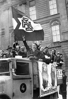 Angehörige der Vaterländischen Front ziehen auf einem Lastwagen wahlwerbend durch die Stadt.