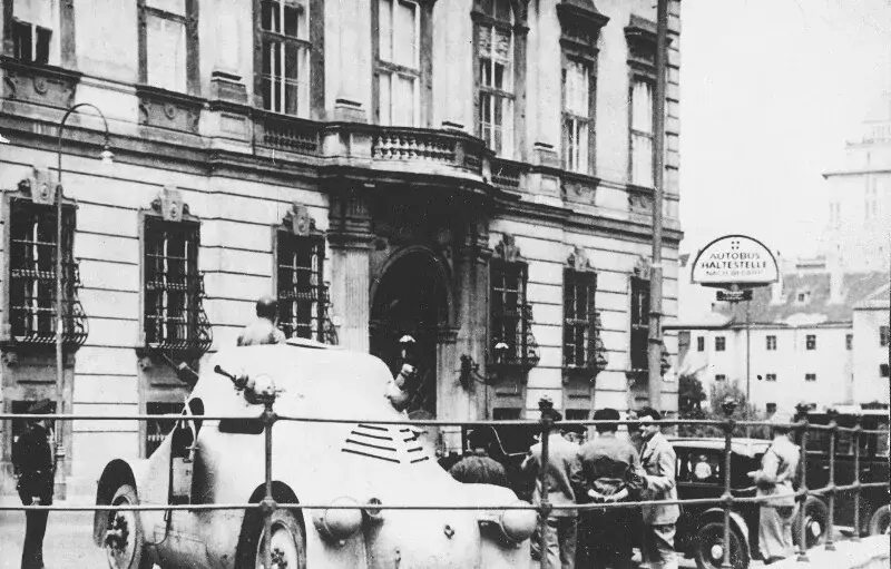 Weisser Panzerwagen mit Maschinengewehren und einigen Personen vor dem Bundeskanzleramt in Wien am 25. Juli 1934.