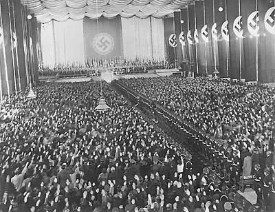 Als Abschluss zum Wahlkampf für die Volksabstimmung zum "Anschluss" Österreichs an das 3. Reich am 10. April, spricht Adolf Hitler am Samstag den 9. April 1938 in der Wiener Nordwestbahnhalle. Blick in die gefüllte Veranstaltungshalle. Eine Hakenkreuzflagge hinter der Tribühne.