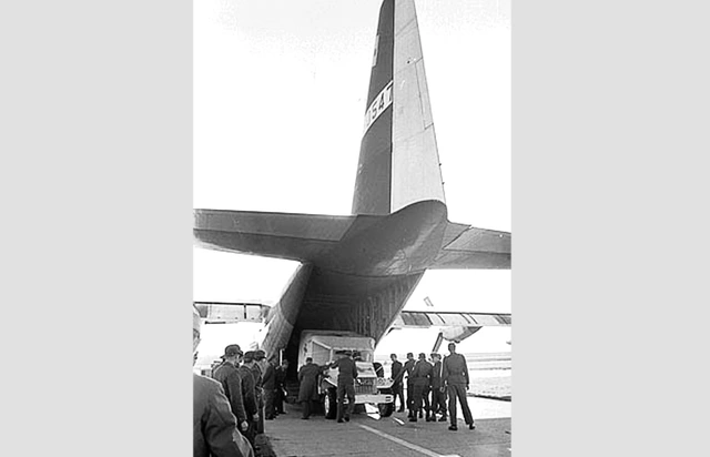 Das Transportflugzeug wird von Soldaten mit dem Wagen beladen.