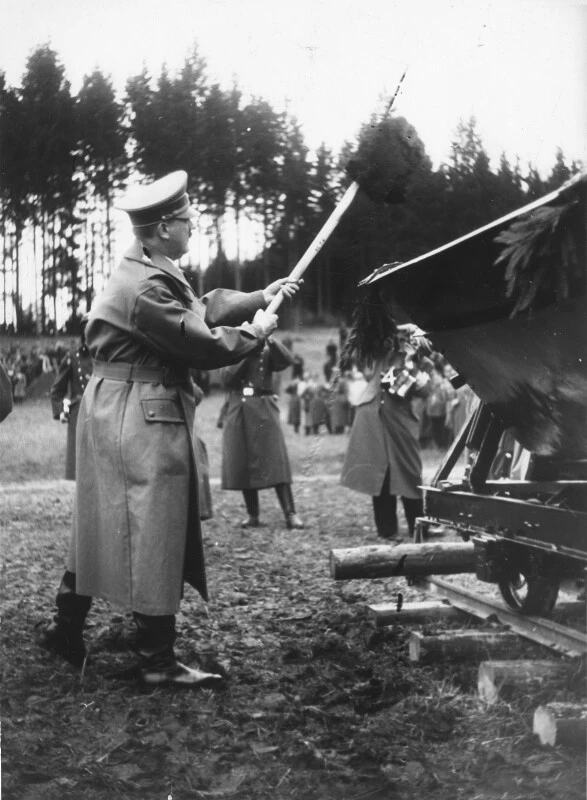 Adolf Hitler beim Spatenstich zum Reichsautobahnbau in Österreich. Walserberg bei Salzburg, am 7. April 1938. Hitler in Uniform wirft mit der Schaufel Erde in einen Eisenbahnwagon.