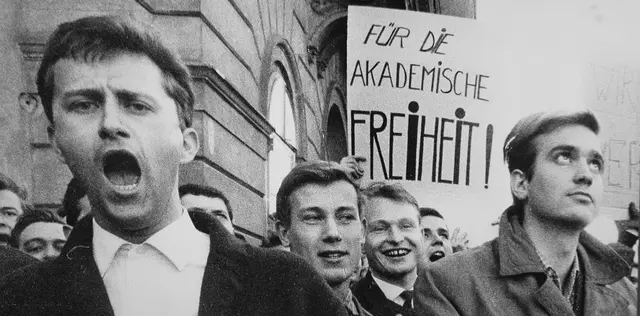 Studentendemonstration. Einige - teilweise schreinende - Studenten vor einem Gebäude mit einem Transparent zu sehen: "Für die akademische Freiheit!"