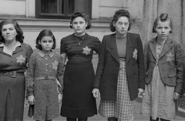 Die jüdische Bevölkerung wird gezwungen einen Judenstern zu tragen. Wien 1941. Fünf Frauen und Mädchen mit Judenstern auf der linken Brust in einem Hinterhof in Wien fotografiert.