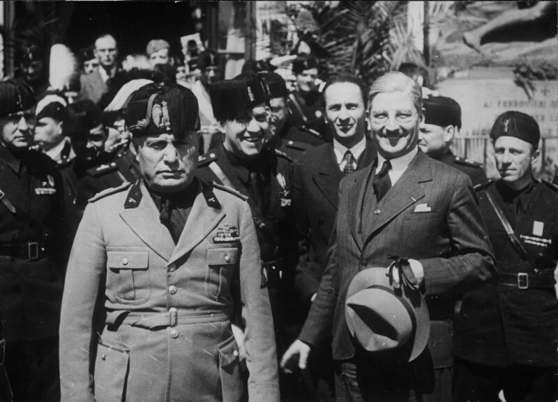 Der österreichische Bundeskanzler Kurt Schuschnigg (rechts) und Staatssekretär Guido Schmidt (hinter Schuschnigg) treffen in Venedig Benito Mussolini (links). Hinter diesem Außenminister Ciano. 22. April 1937. Die Österreicher in Anzug, die Italiener in Uniform.