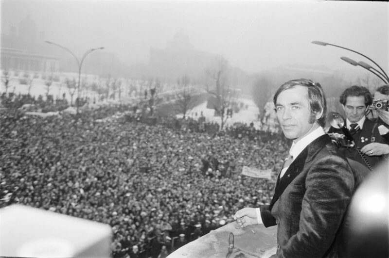 Blick über den gefüllten Ballhausplatz. Karl Schranz rechts am Balkon stehend. 