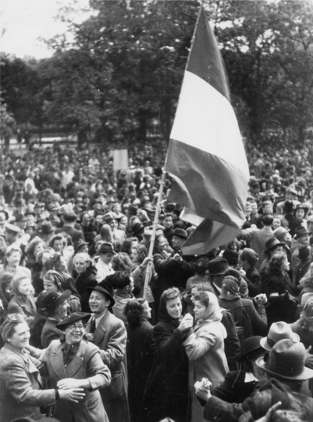 Fotografie einer jubelnden Menge mit Österreichflagge, Wien 1945